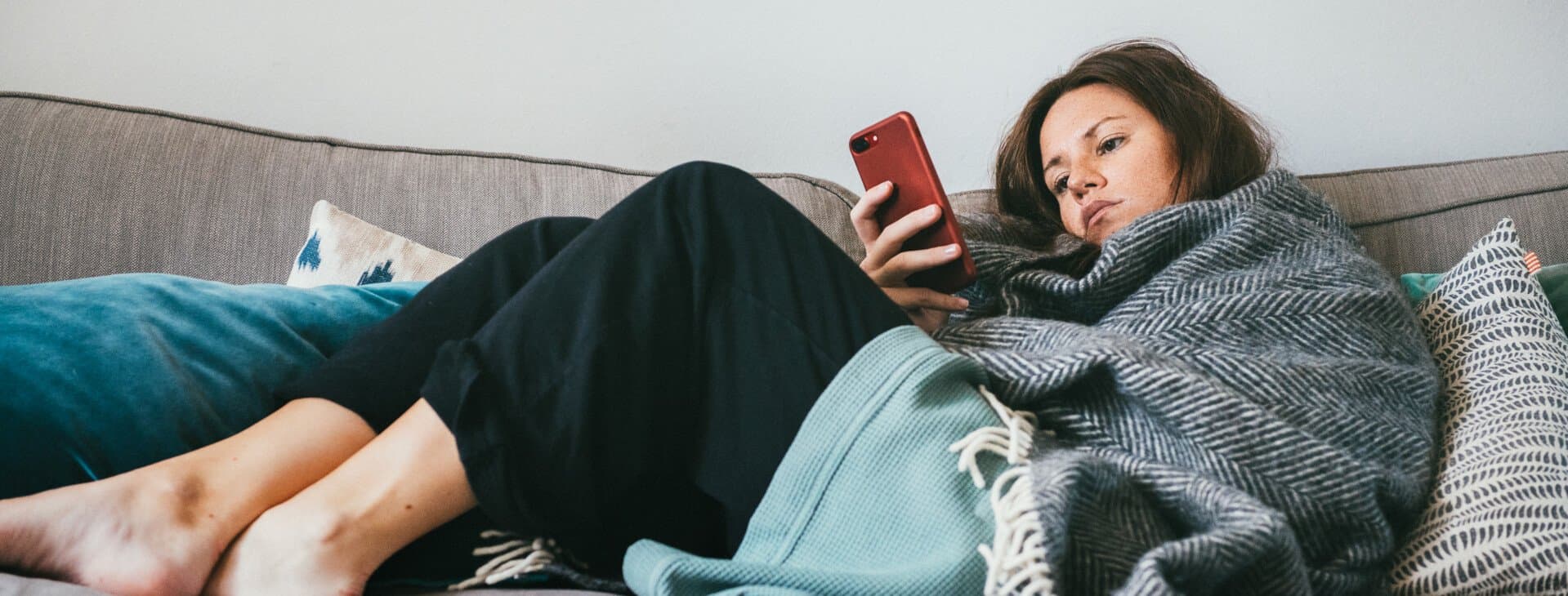 Tjej ligger i soffan med influensa