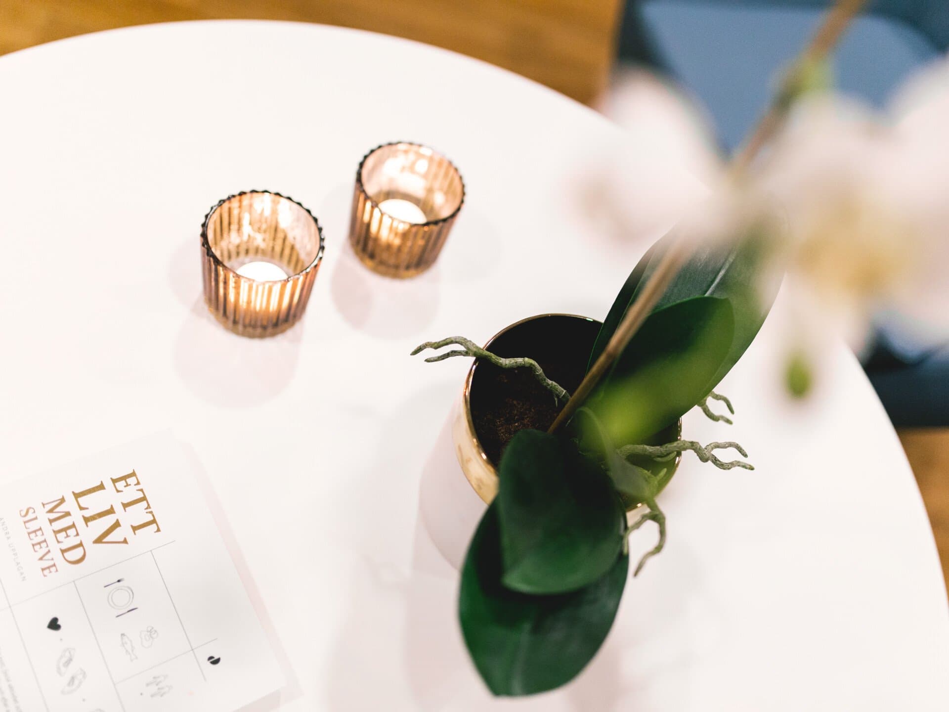 Bord med ljus, blomma och boken "Ett liv med sleeve"