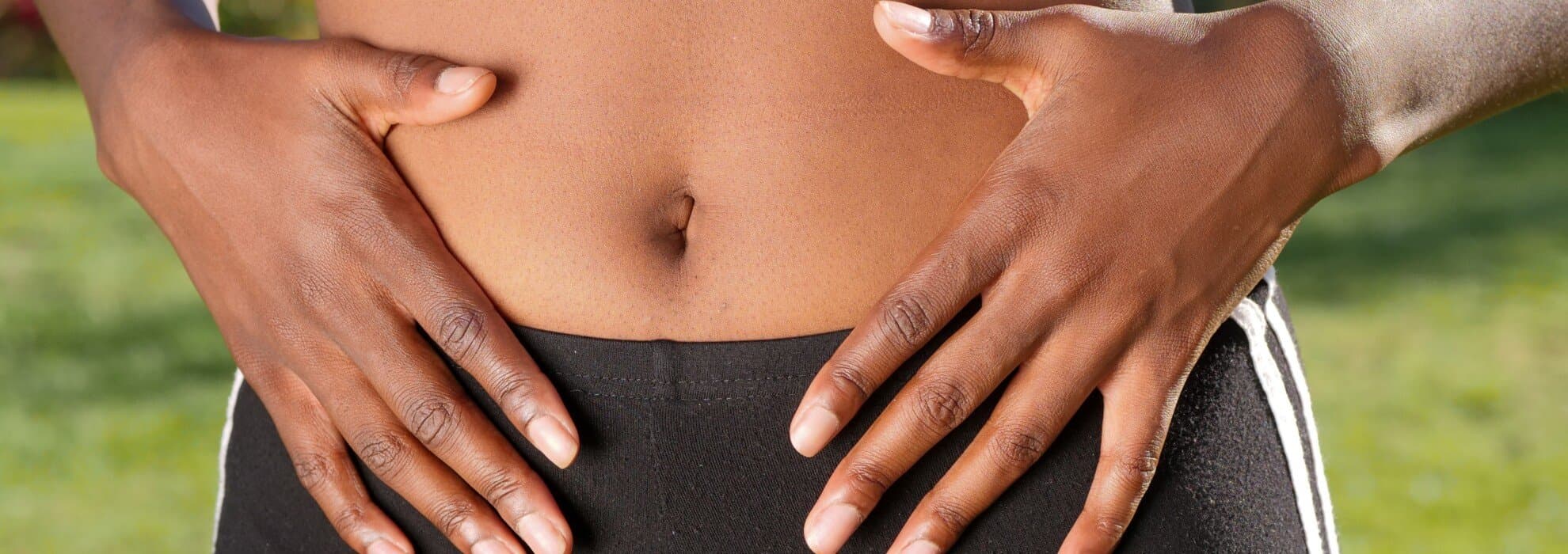 Kvinna håller händerna på magen