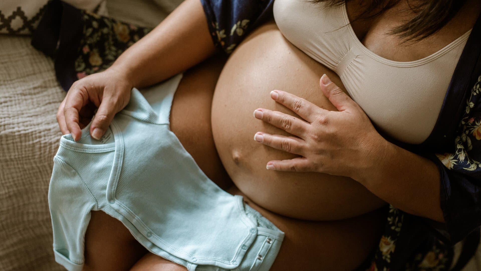Gravid kvinna med bebiskläder Gravid kvinna med bebiskläder