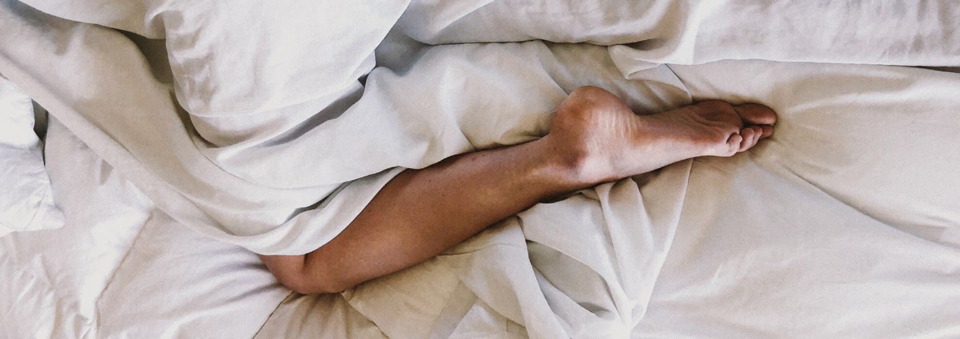 Person ligger i en säng.