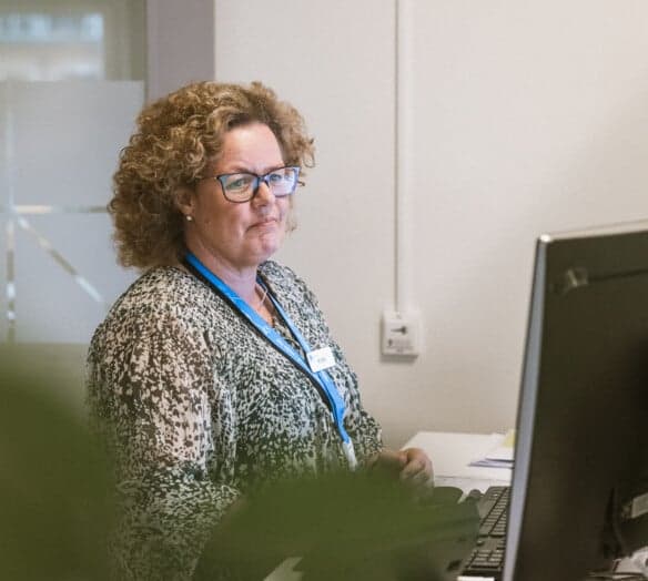 Medarbetare står vid dator