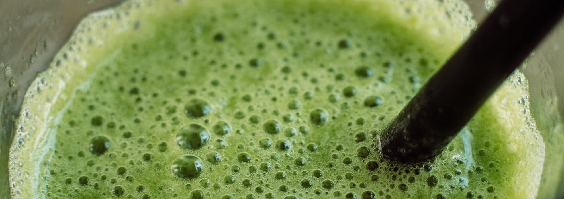 Person dricker den gröna smoothien som just mixats