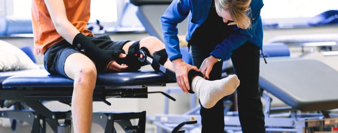 fysioterapeut undersöker en patient med korsbandsskada