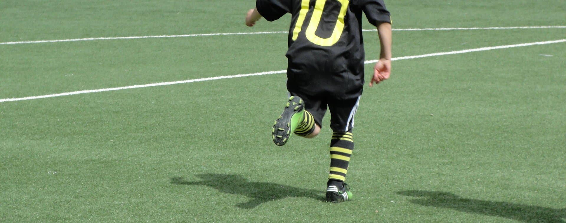 liten pojke spelar fotboll