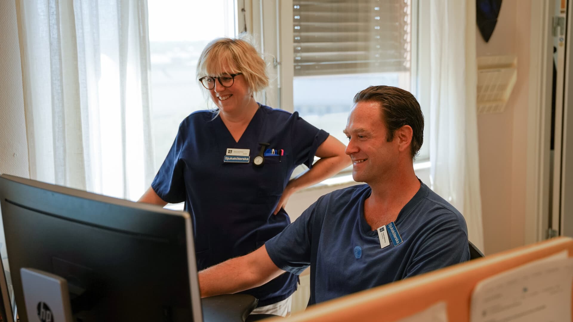 Två medarbetare tittar på en datorskärm Två medarbetare tittar på en datorskärm