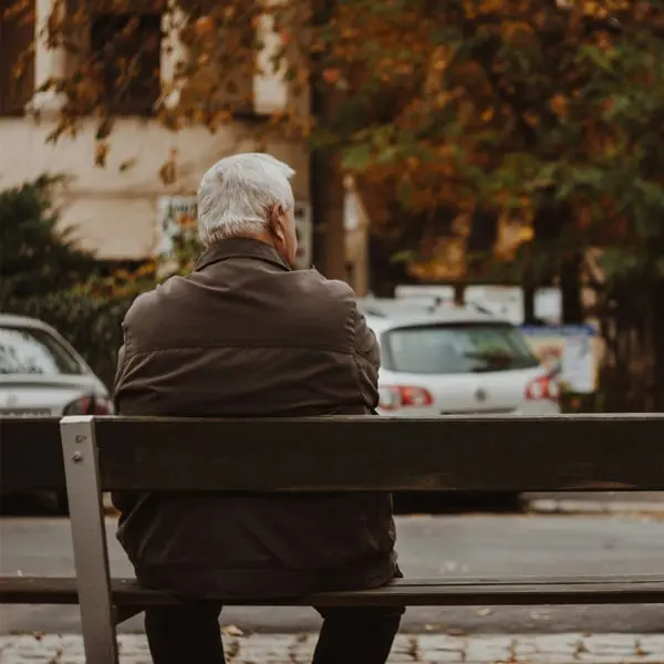 Man sitter på parkbänk Man sitter på parkbänk