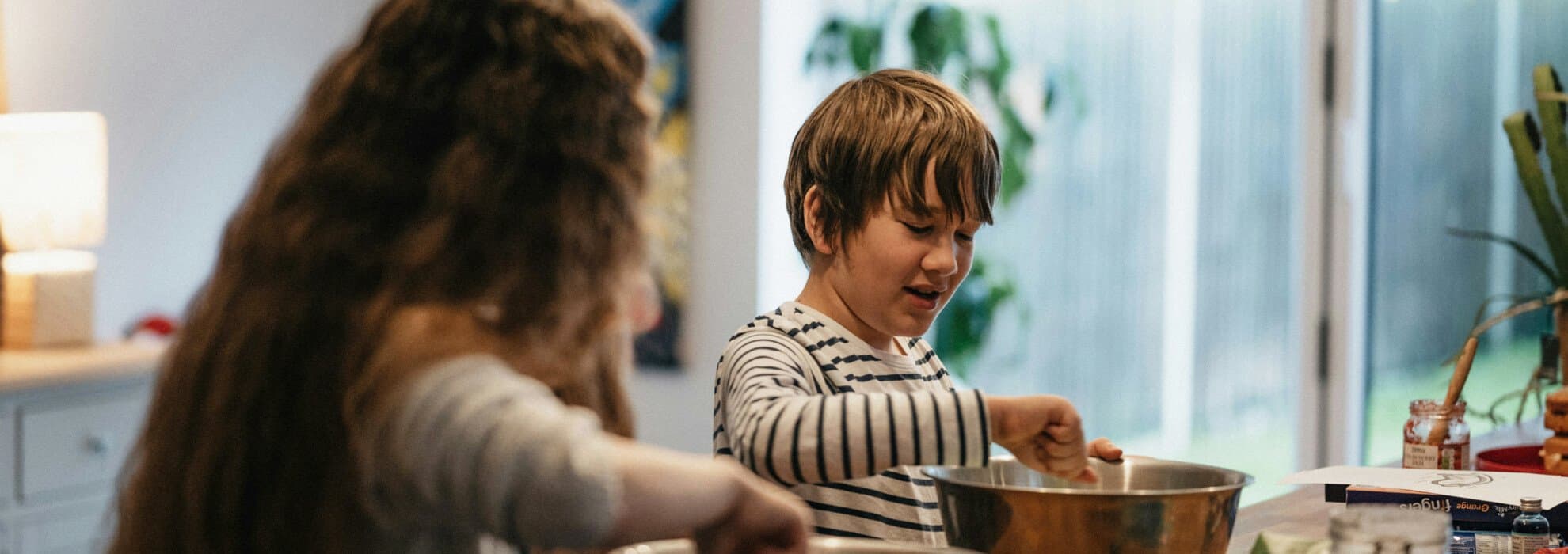 Barn lagar mat i ett kök Barn lagar mat i ett kök