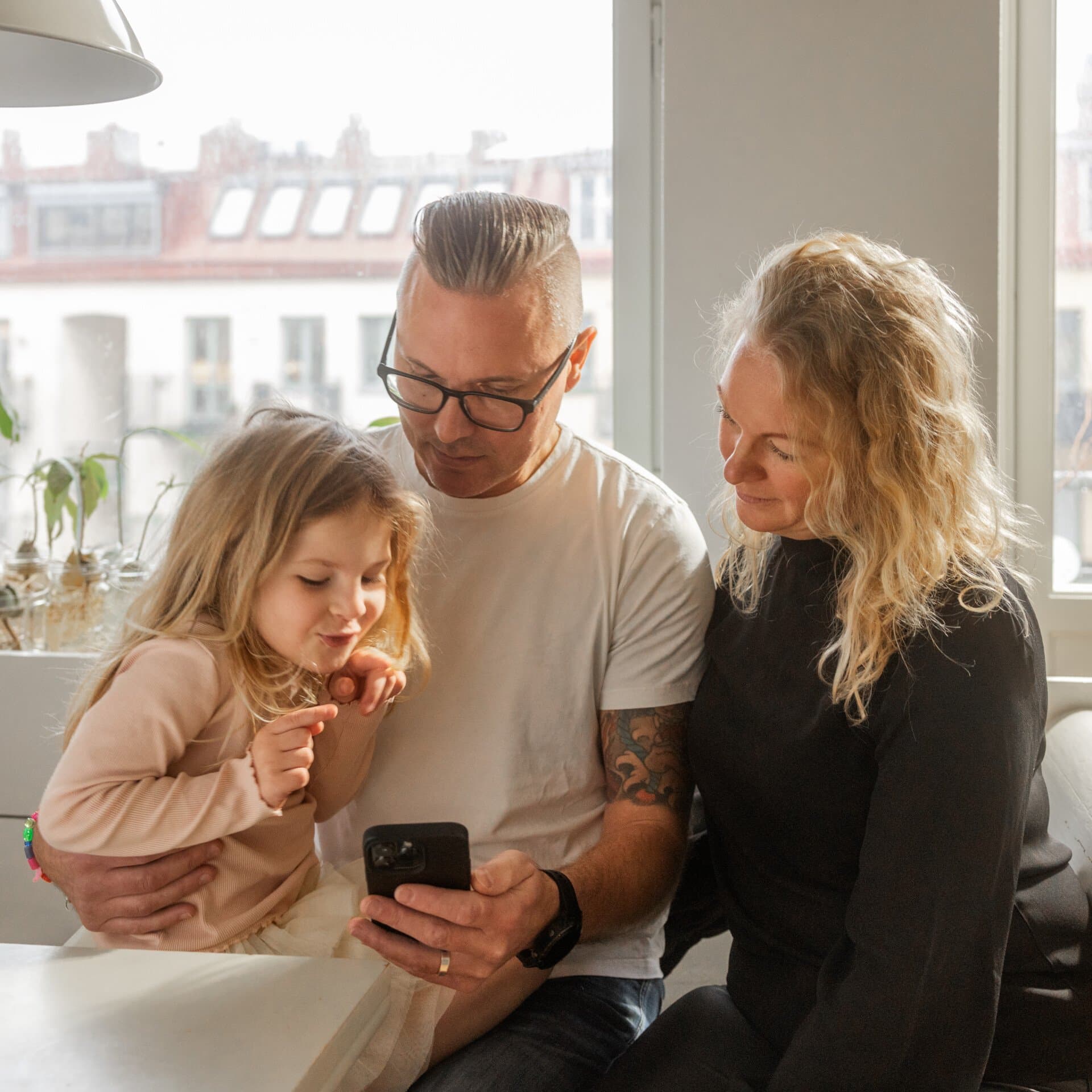 Familj tittar i mobilen Familj tittar i mobilen