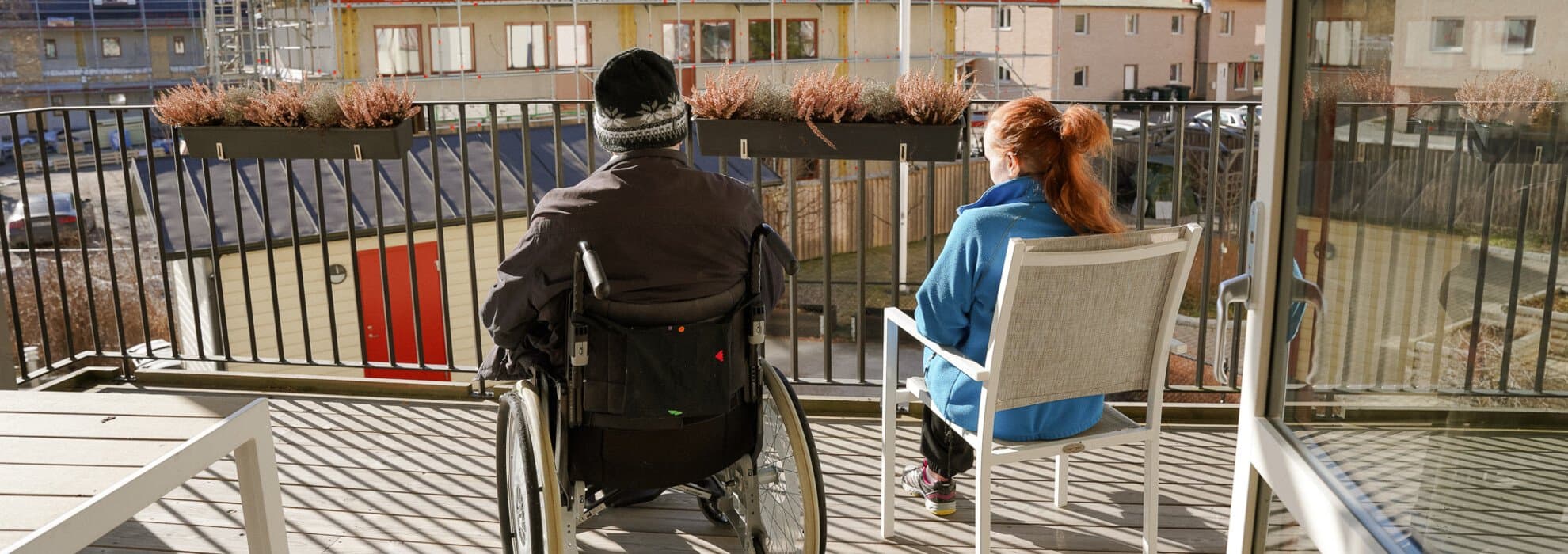 Patient i rullstol och personal på balkong Patient i rullstol och personal på balkong