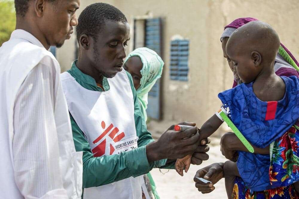 Personal från Läkare Utan Gränsen som mäter armen på en flicka för att se om hon är undernärd i Ndougoury village i Tchad