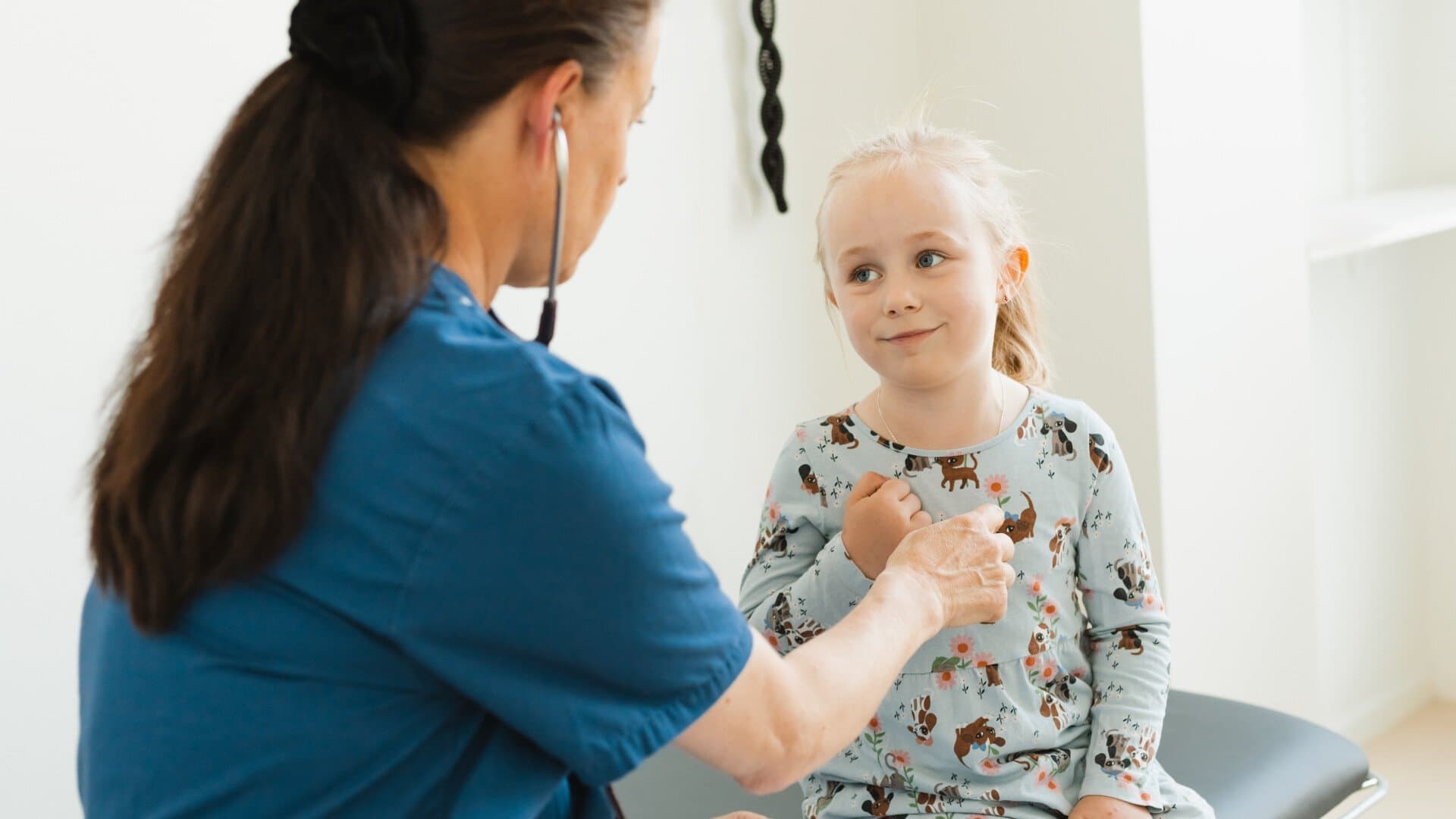 Läkare pratar med ett barn i ett mottagningsrum