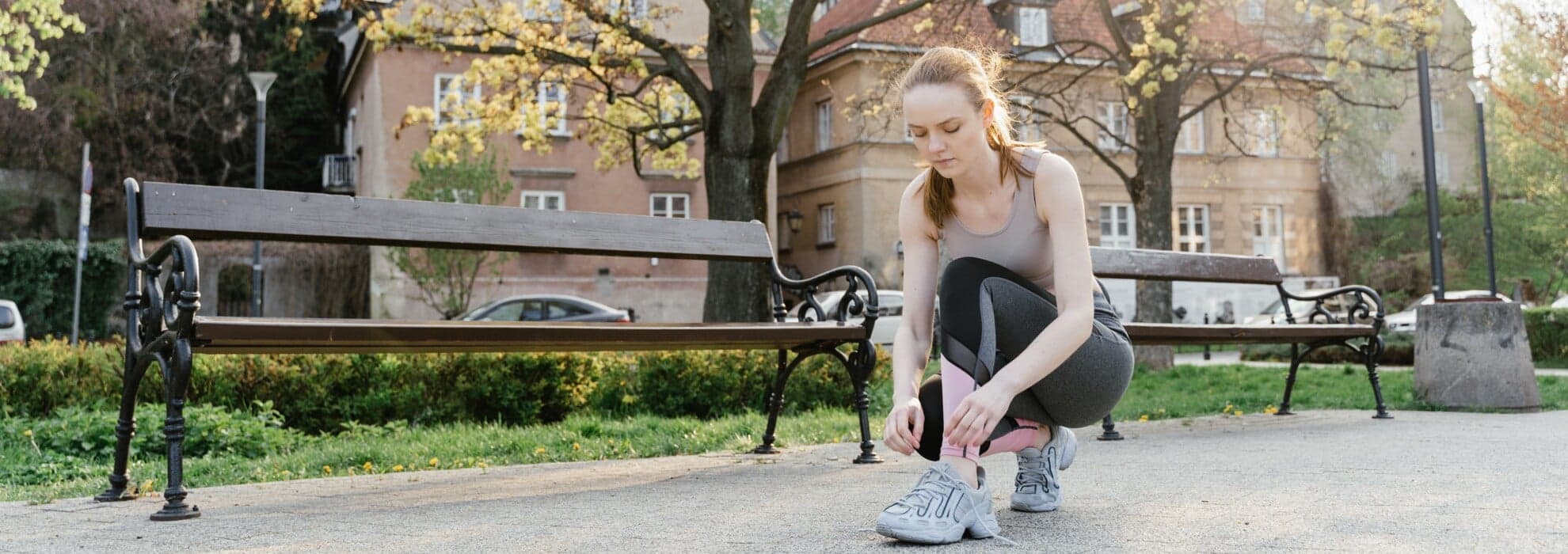 kvinna utomhus som knyter sina joggingskor