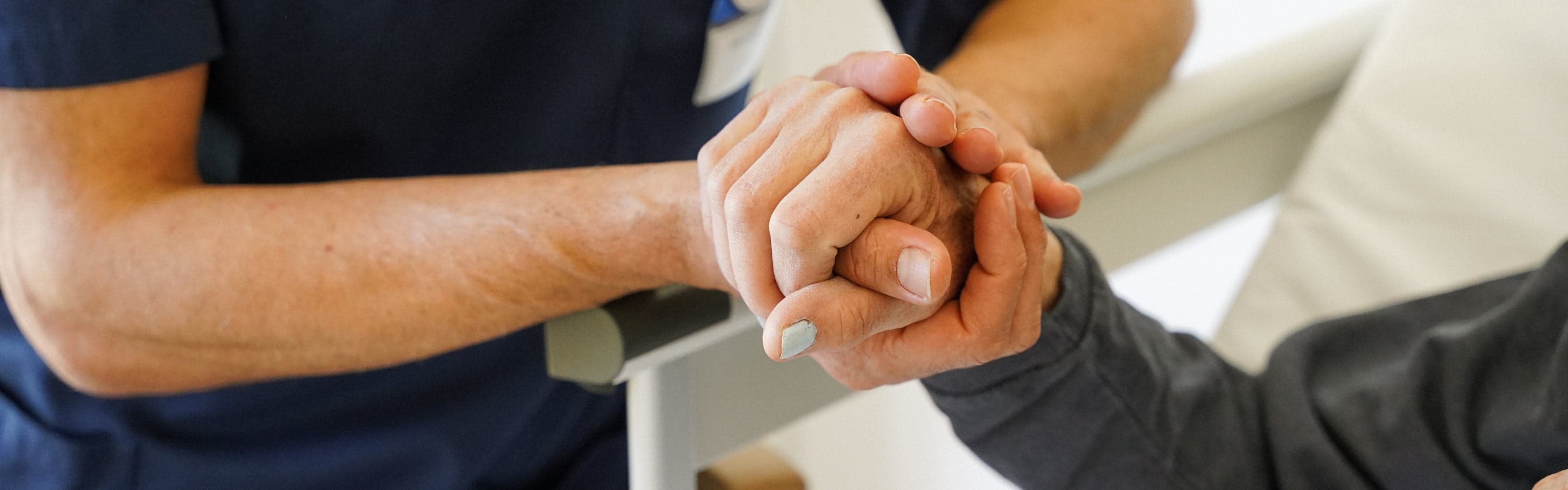 Vårdpersonal håller i patients hand Vårdpersonal håller i patients hand