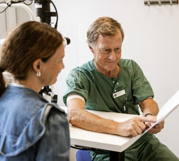 Ögonläkare visar papper för patient Ögonläkare visar papper för patient