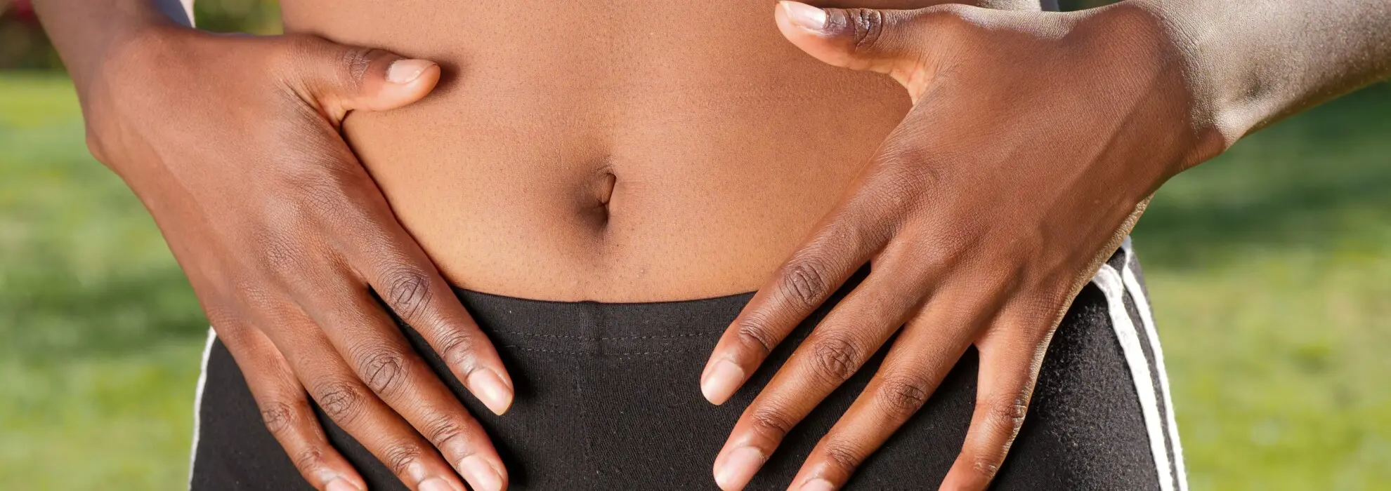 Kvinna håller händerna på magen