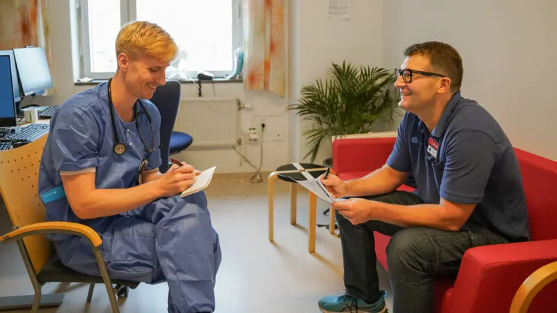 Två män som sitter och pratar i med varandra