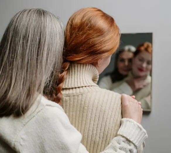 två kvinnor tittar i spegeln