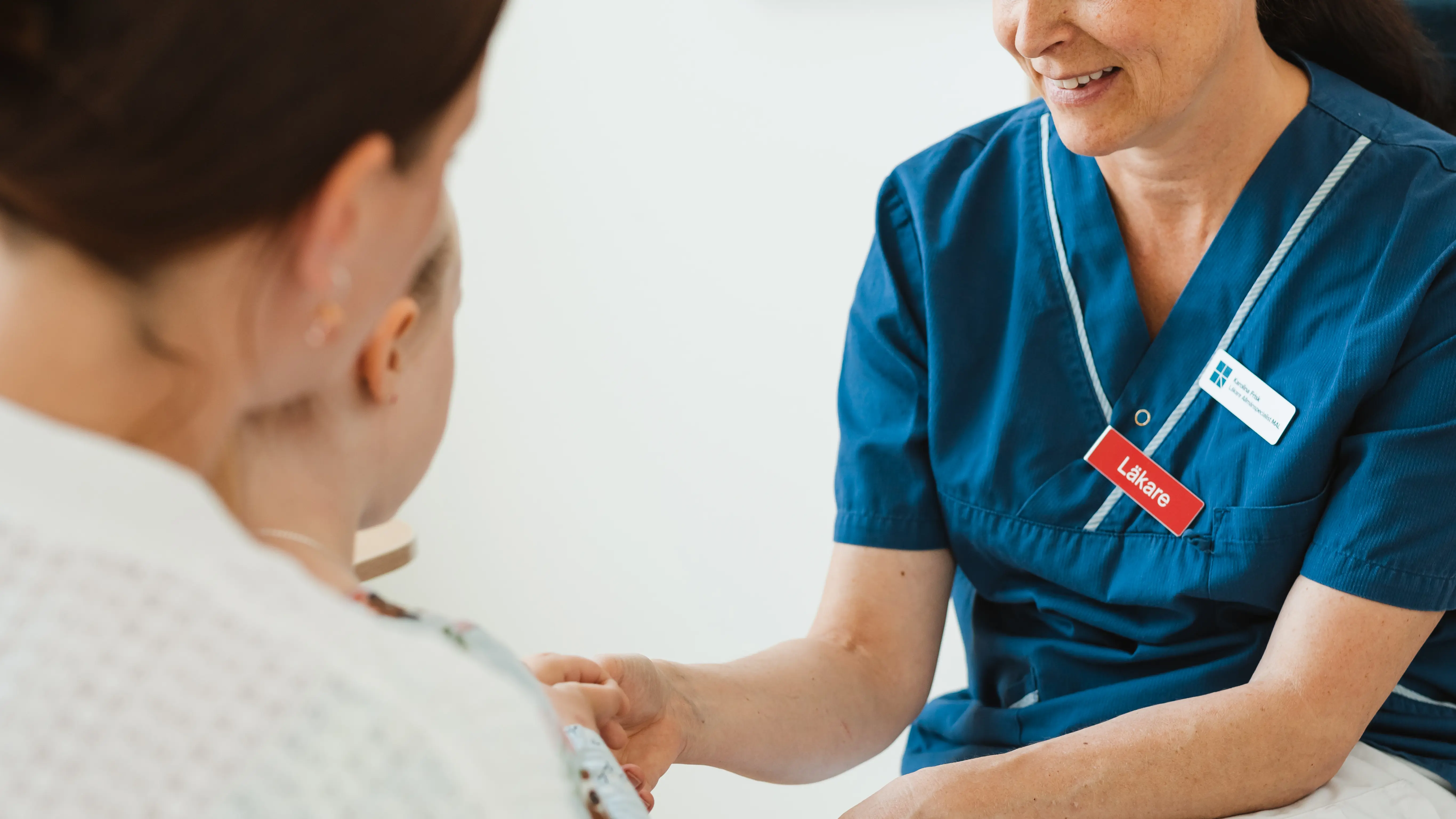 Läkare som pratar med barn och vuxen