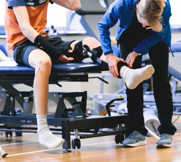 fysioterapeut justerar ortos på akut knäpatient