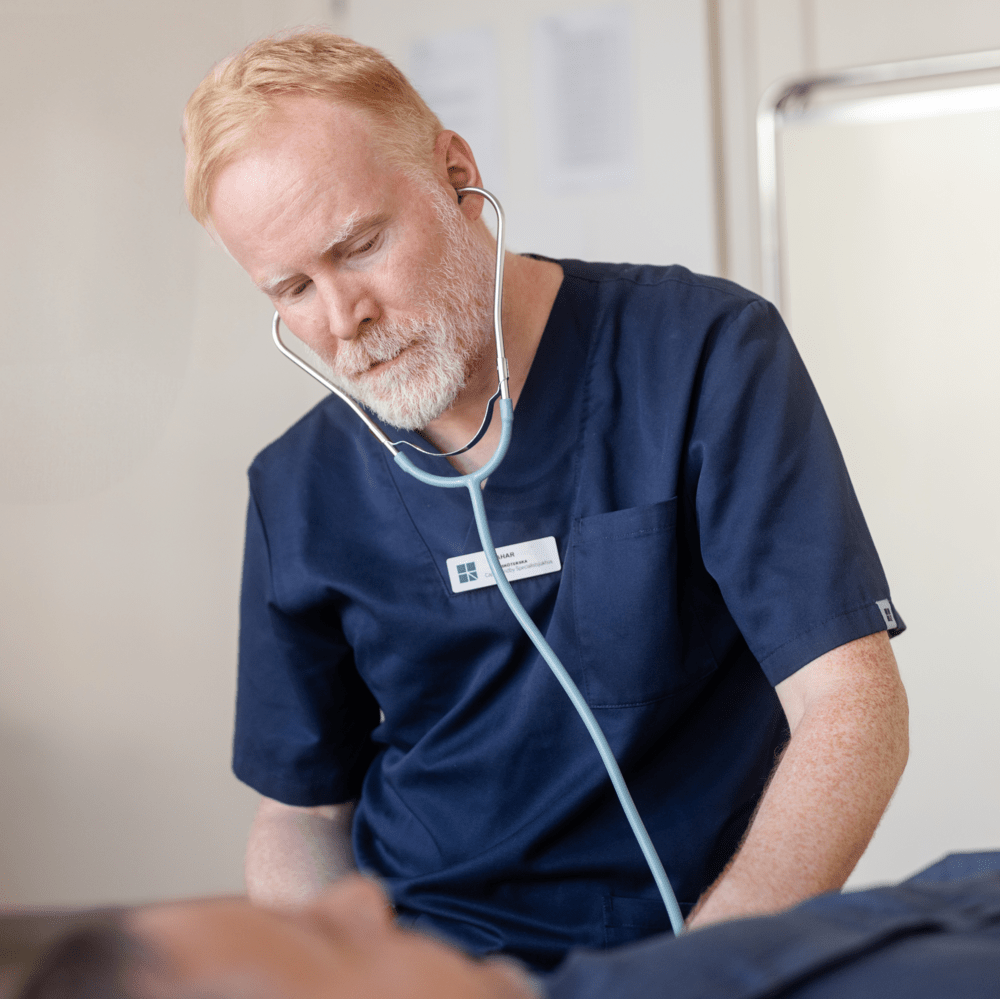 Läkare lyssnar på patient med stetoskop