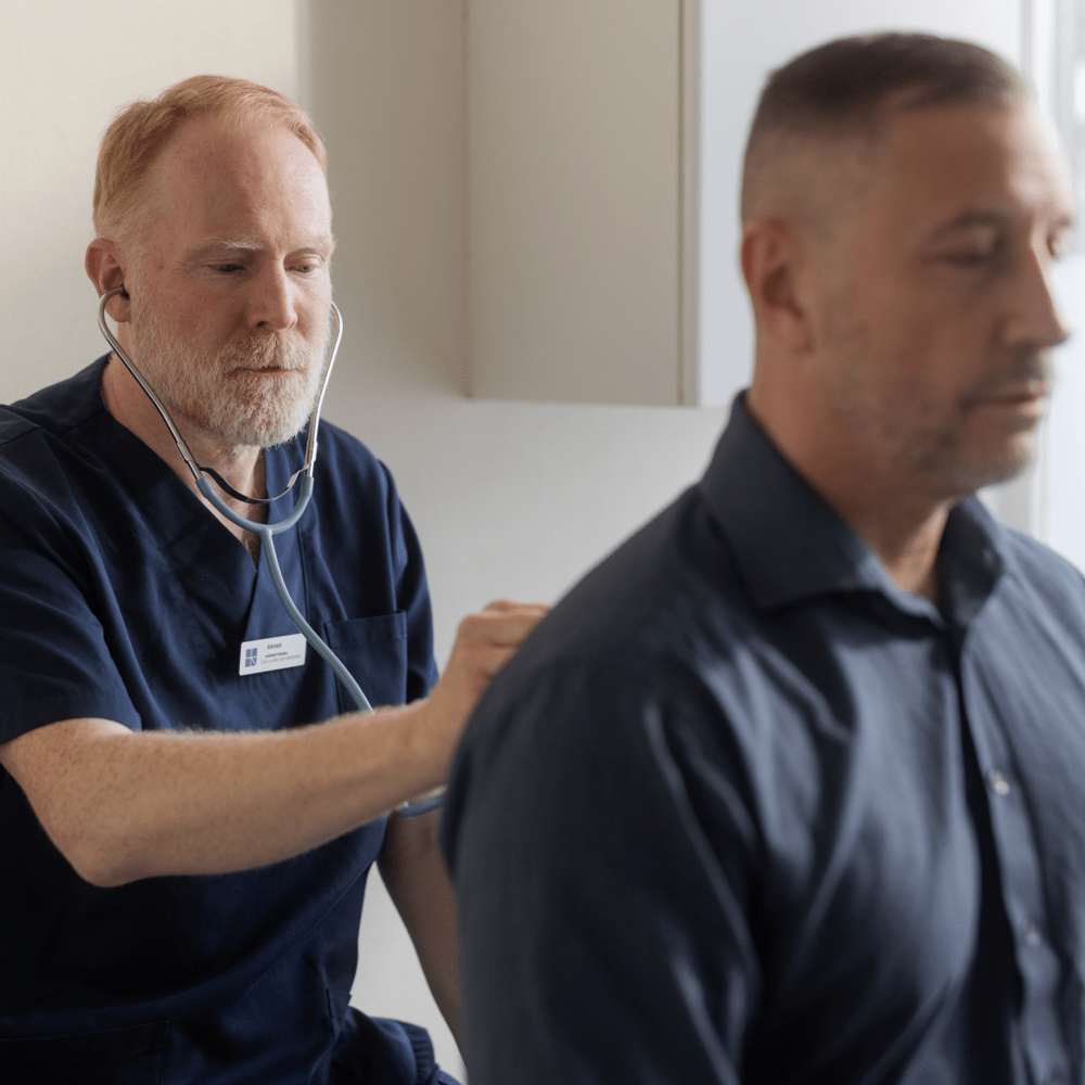 Läkare lyssnar på patients lungor