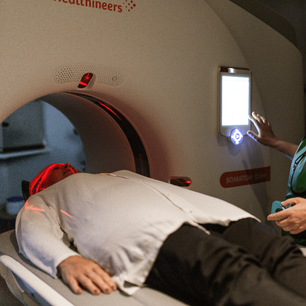 Person som blir röntgad. Vårdpersonal bredvid.