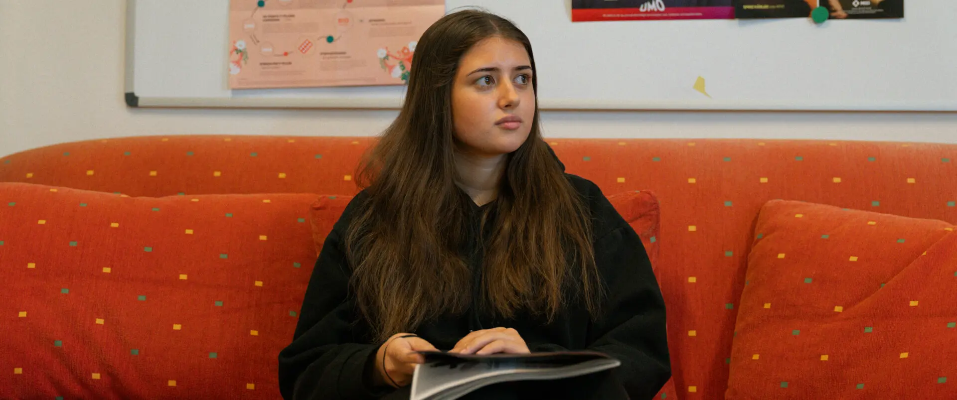 Ungdom sitter i soffa med tidning