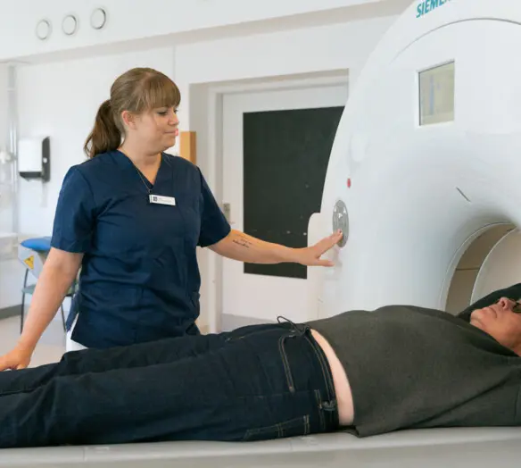 Person som blir röntgad. Vårdpersonal bredvid.