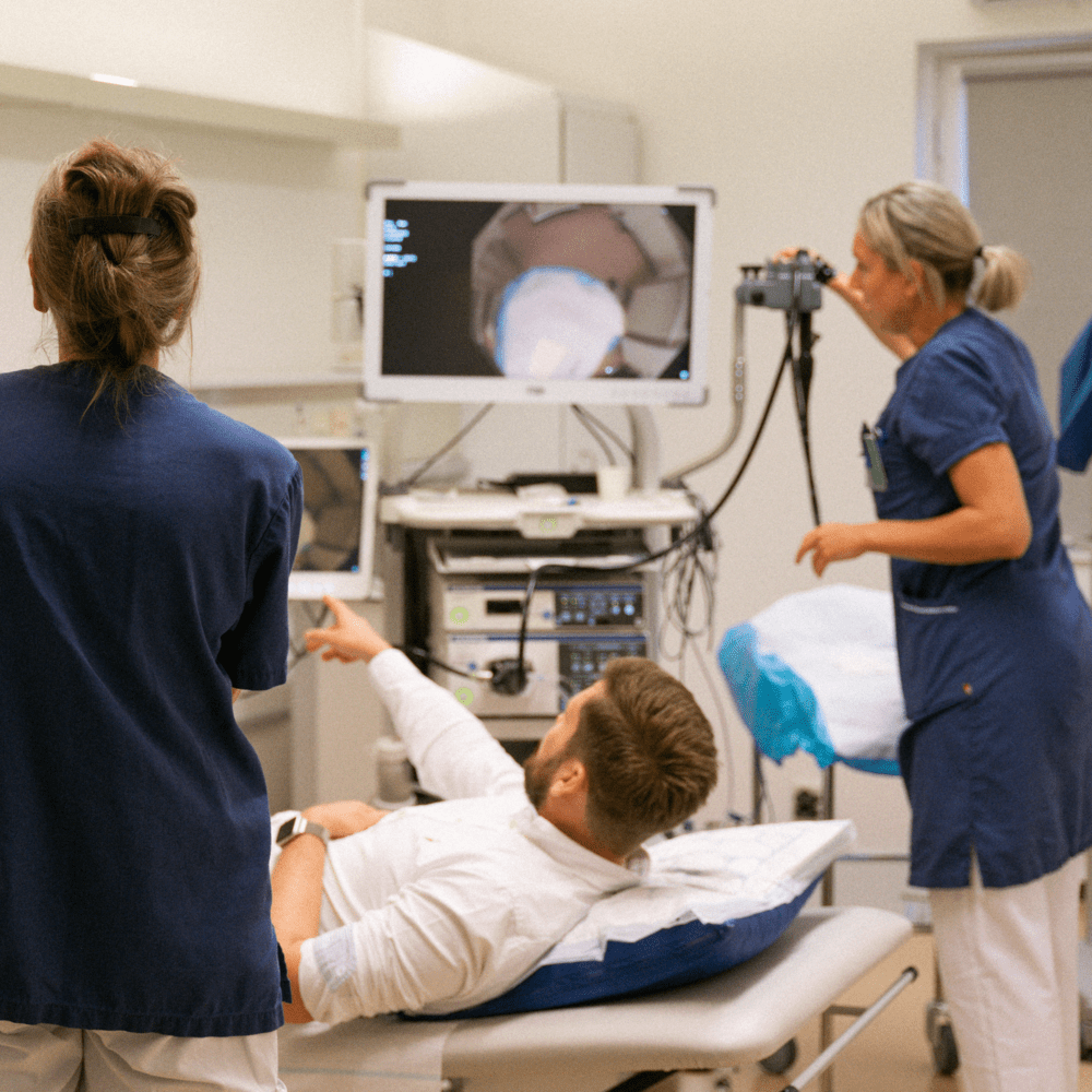 Patient pratar med sjuksköterskor liggandes på brits