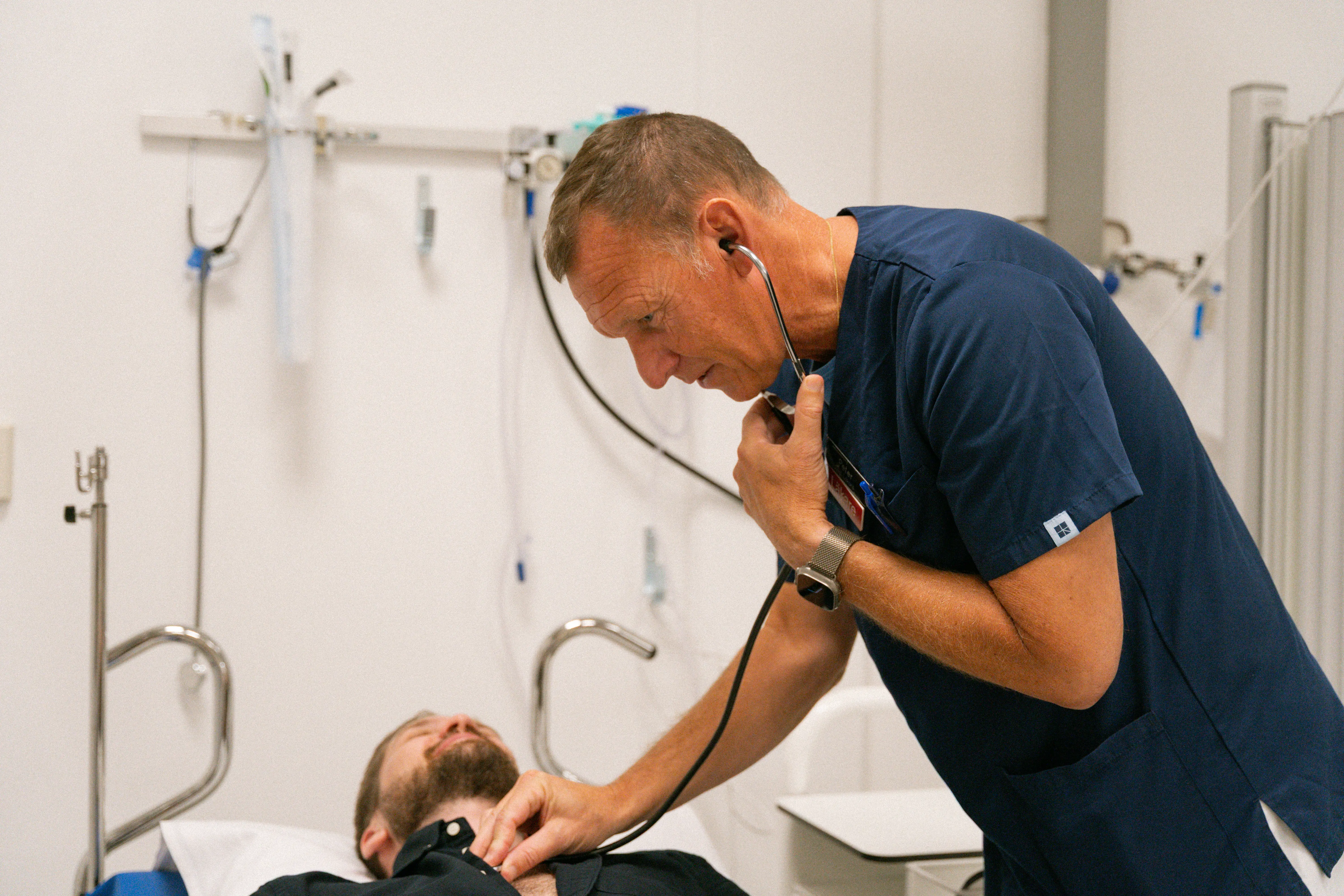 Läkare lyssnar på patients hjärta